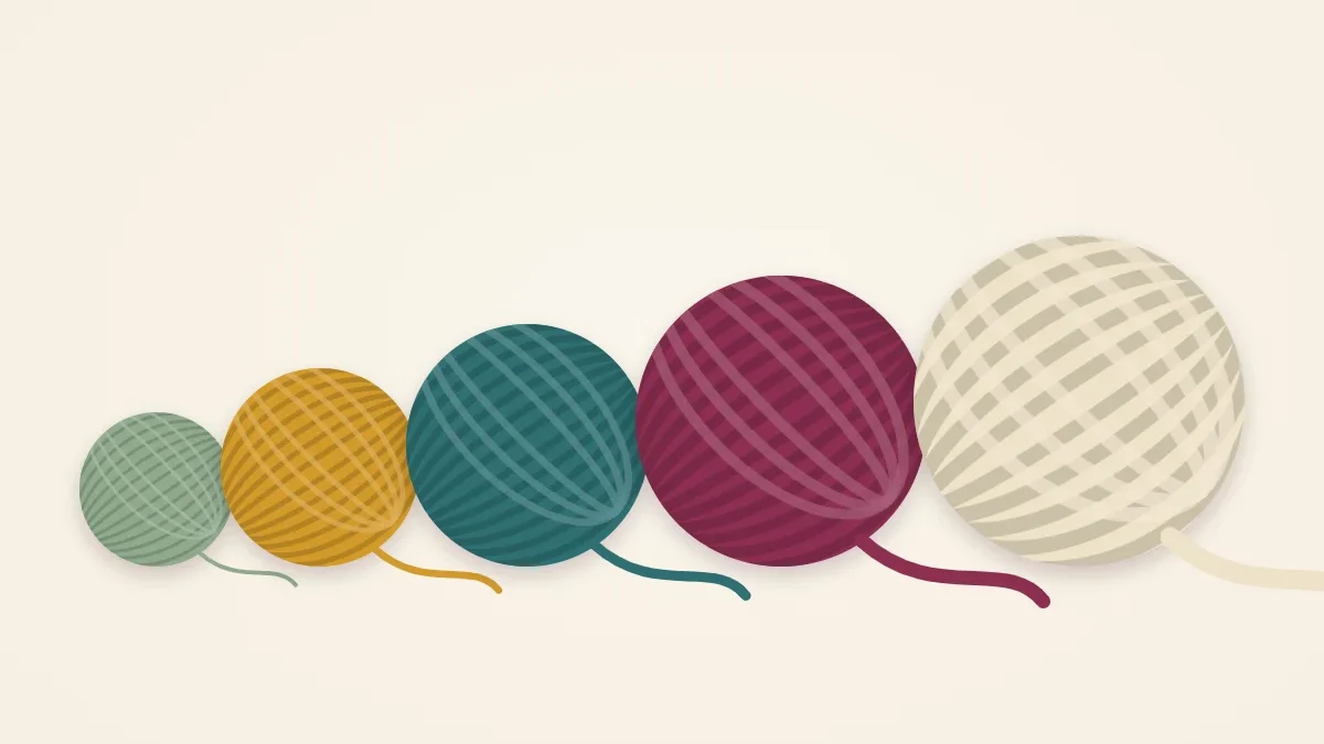 Five balls of yarn lined up from thinnest to thickest in warm colors