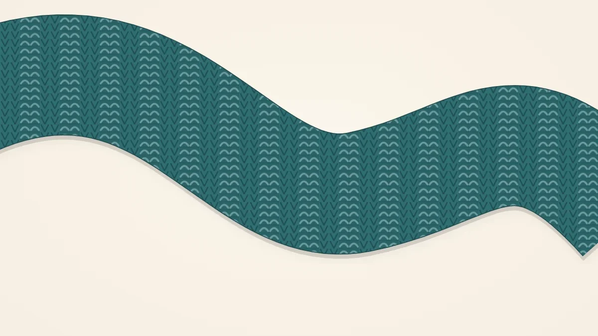 A 2x2 ribbed knitted scarf in deep teal lying in a soft curve